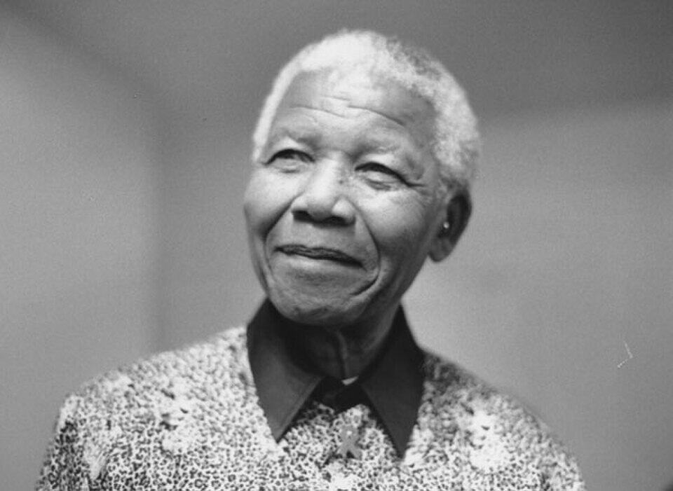 Elderly woman with short white hair, wearing a patterned blouse, looking thoughtfully into the dista.